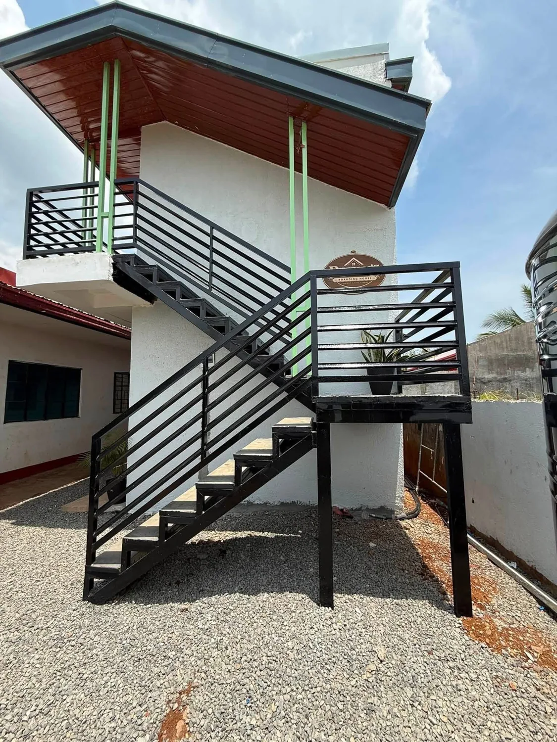 Exterior staircase and Rohan’s Boarding House sign in Alae, Manolo Fortich